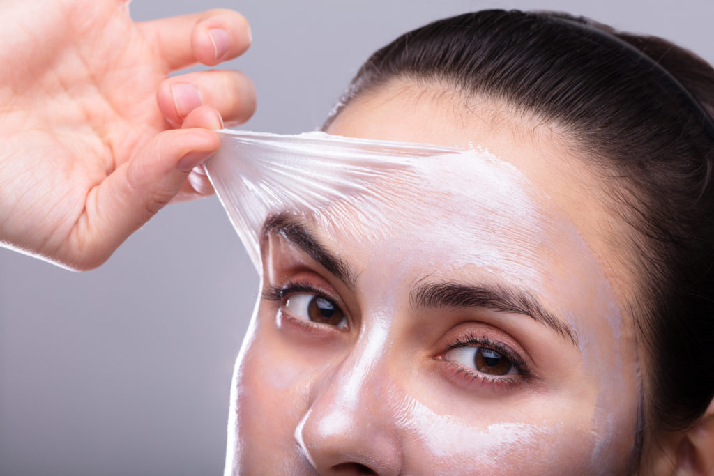 Woman revealing refreshed skin post facial treatment at Ayana Dermatology & Aesthetics.